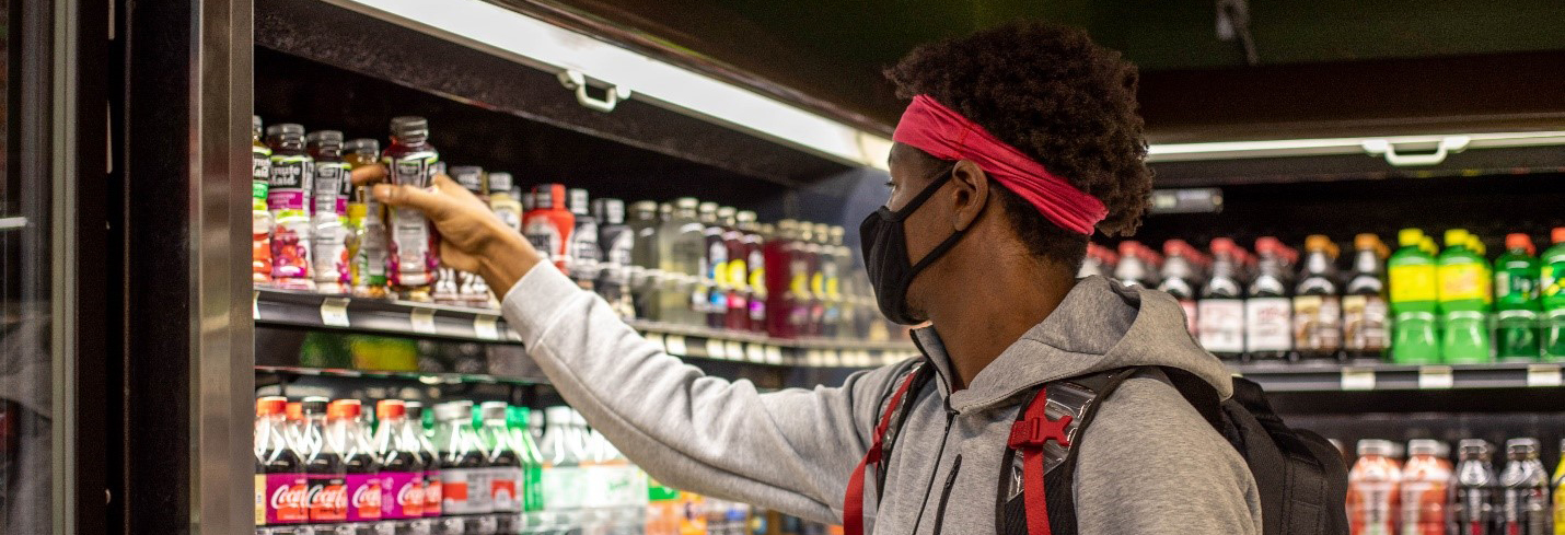 student wearing mask grabs a drink
